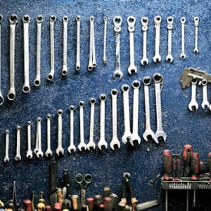 Neatly arranged wrenches and tools on a workshop wall, ideal for mechanics.