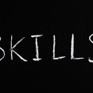 Chalk lettering of the word 'skills' on a blackboard, emphasizing learning and education.